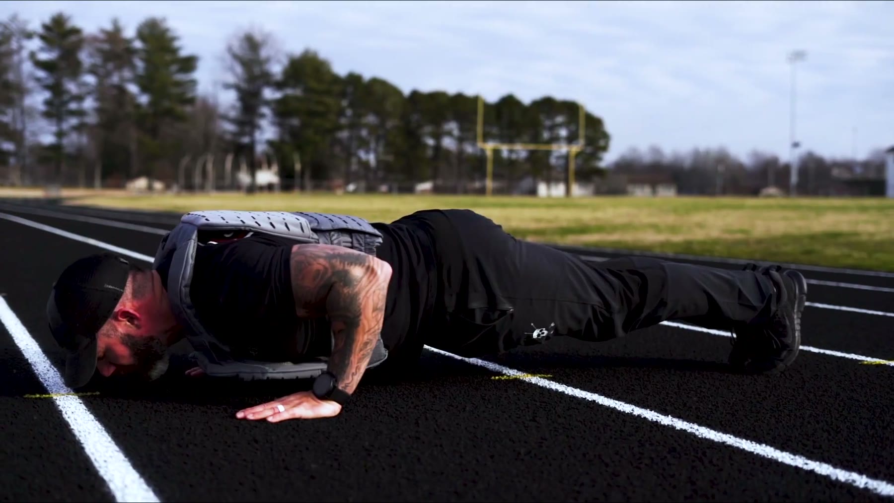 Push-up on a running track in the Wolf weighted vest plate carrier