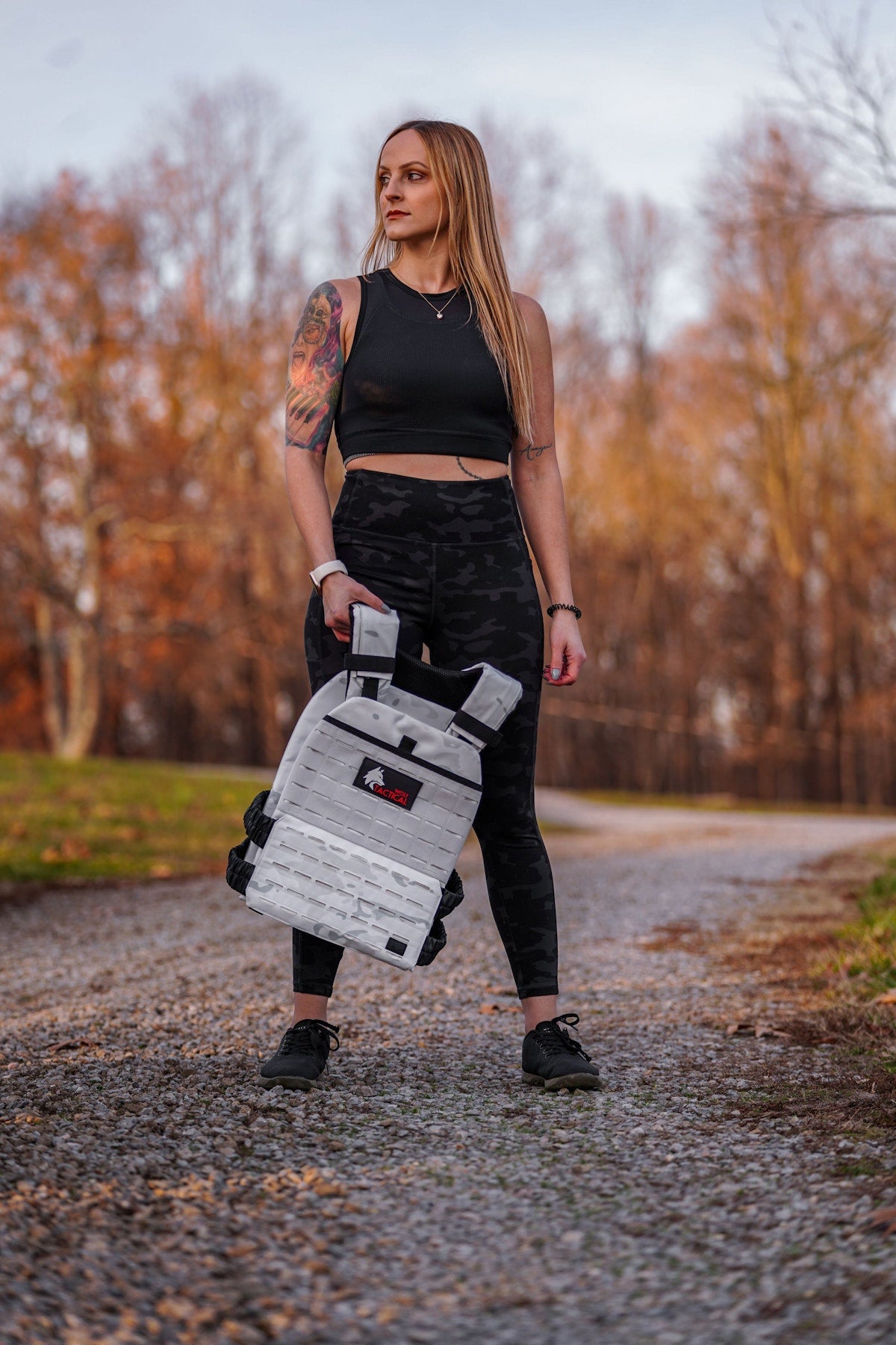 Holding a Wolf weighted vest on a gravel path
