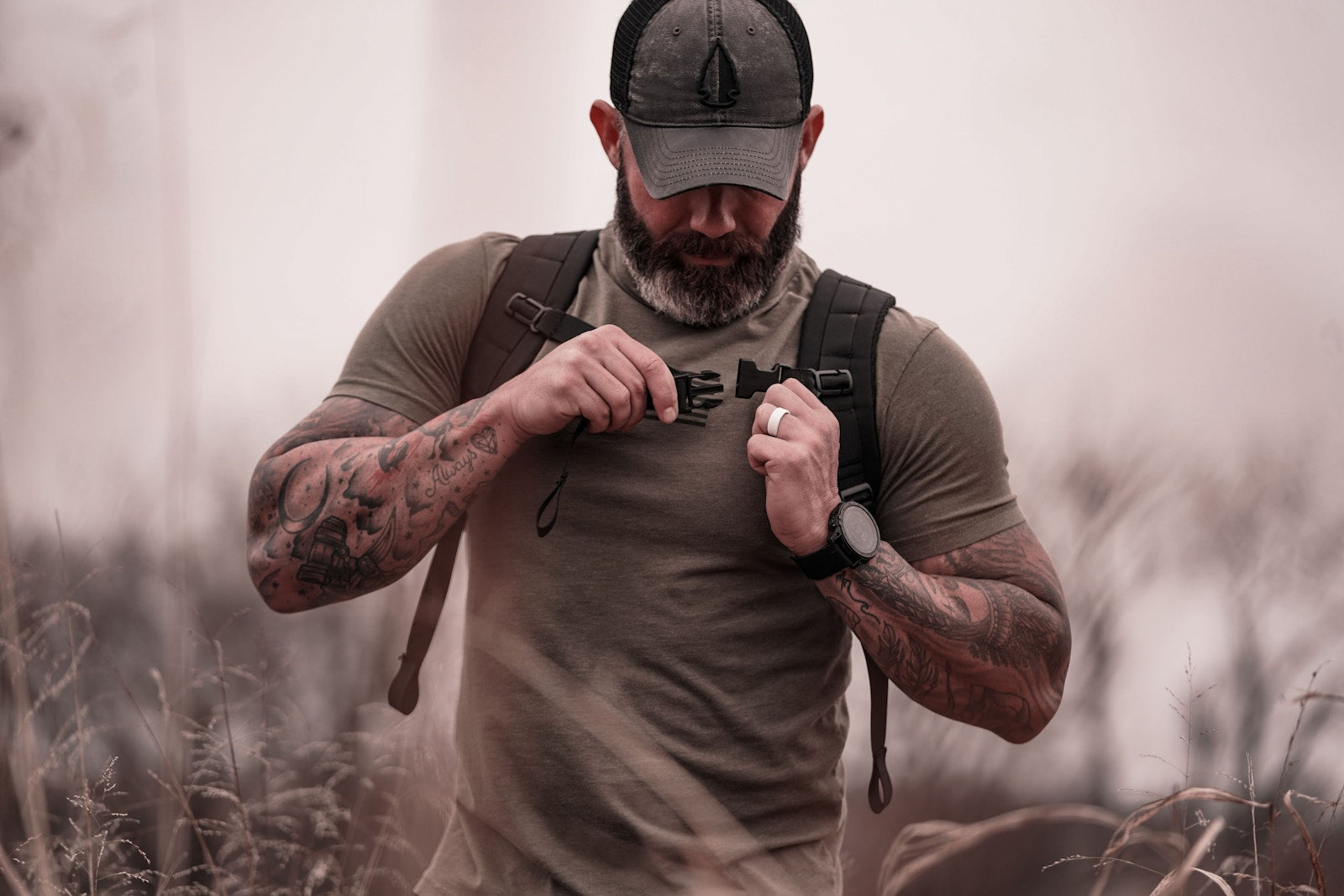 Shouldering a rucking backpack in an open field