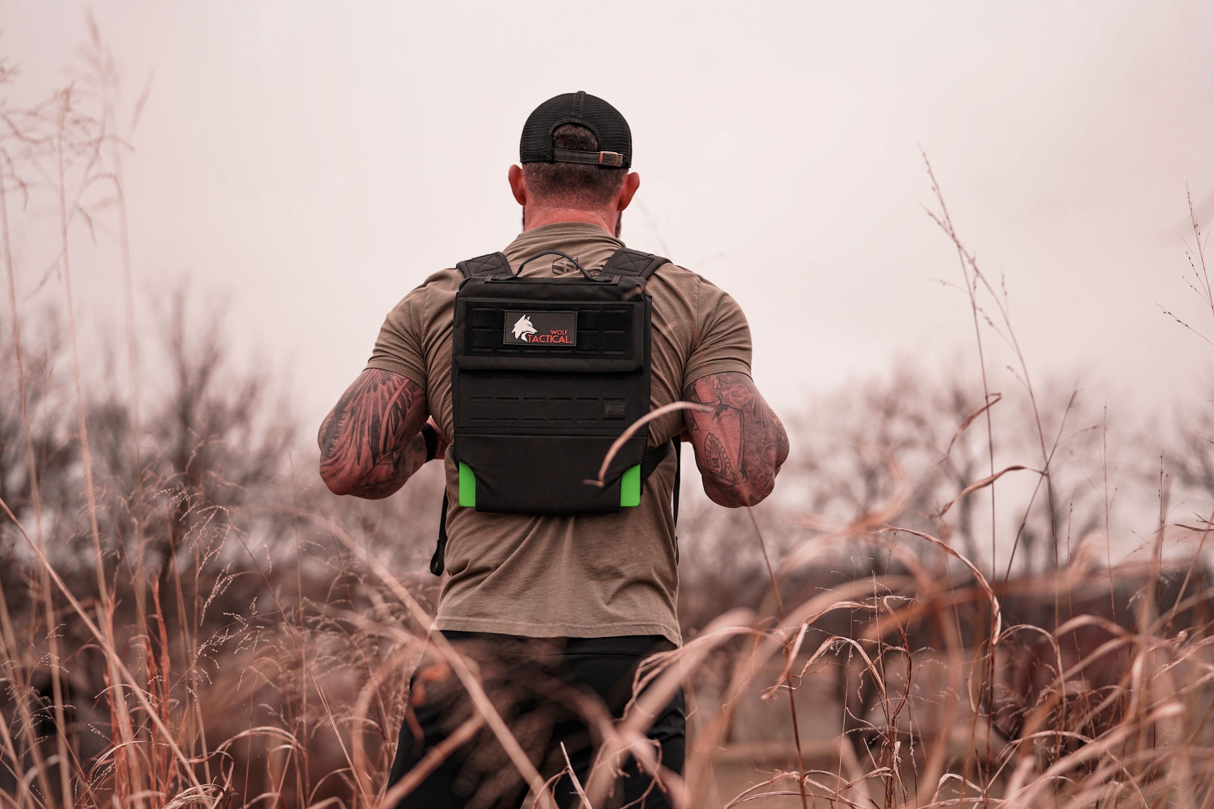 Man walking out through a winter field in a Wolf plate carrier